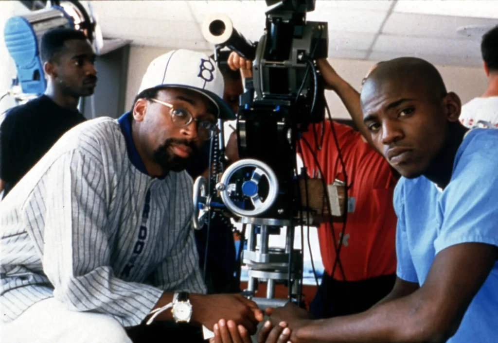 pike Lee net worth: A smiling portrait of the acclaimed director in a sharp suit, exuding confidence and success.